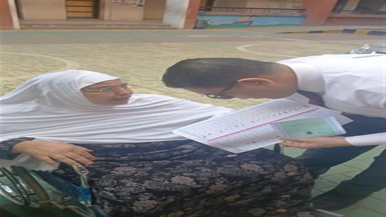 قاضٍ يساعد مسنة على الإدلاء بصوتها داخل لجنة في البحيرة
