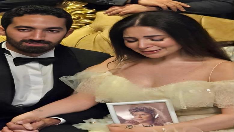 مي عز الدين تحمل صورة والدتها خلال عقد قرانها