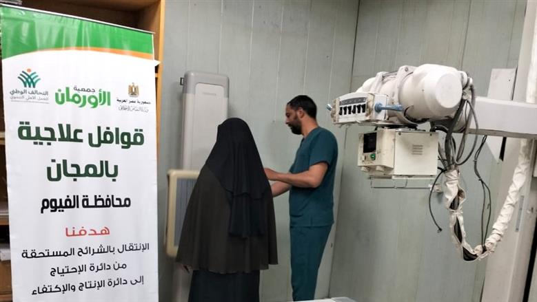 توقيع الكشف على إحدى المرضى خلال القافلة