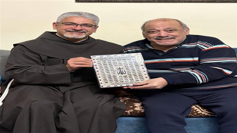 الأب بطرس دانيال يهدي ضياء الميرغني لوحة أسماء الله الحسني بعد الاطمئان على صحته