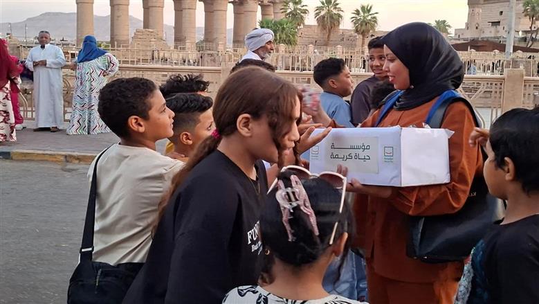 متطوعو حياة كريمة يشاركون فرحة عيد الأضحى مع أهالي الأقصر بساحة سيدي أبو الحجاج ملخص متطوعو مبادرة «حياة كريمة» شاركوا أهالي الأقصر أجواء الاحتفال بعيد الأضحى بساحة سيدي أبو الحجاج، وسط فعاليات ترفيهية وتوزيع هدايا للأطفال. الأجواء شهدت تفاعلا كبيرا من الأسر والأطفال في واحدة من أبرز ساحات الاحتفال بالعيد في الأقصر. شهدت ساحة سيدي أبو الحجاج بمدينة الأقصر، صباح اليوم، أجواء احتفالية مميزة تزامنا مع احتفالات عيد الأضحى المبارك، حيث حرص متطوعو مبادرة حياة كريمة على مشاركة الأهالي فرحة العيد من خلال تنظيم عدد من الفعاليات الترفيهية وتوزيع الهدايا على الأطفال وسط حالة من البهجة والسعادة. وشهدت الساحة توافد المئات من الأسر والأطفال عقب أداء صلاة العيد، للمشاركة في الفعاليات التي تضمنت فقرات ترفيهية ورسم البسمة على وجوه الأطفال، في أجواء عكست روح المحبة والتكاتف بين الجميع. أجواء احتفالية مبهجة للأطفال والأسر وأكد عدد من المتطوعين أن المشاركة تأتي في إطار حرص المبادرة على التواجد وسط المواطنين في المناسبات المختلفة، وإدخال الفرحة على الأطفال والأسر خلال أيام العيد. وقال أحد المتطوعين: