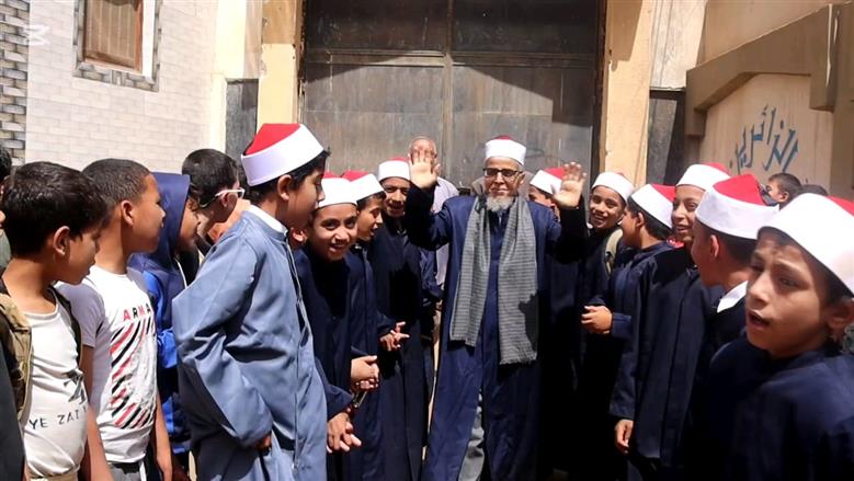 بالزي الأزهري طلاب معهد ديني ببني سويف ينظمون ممر شرفي لأمين التغذية لخروجه على المعاش