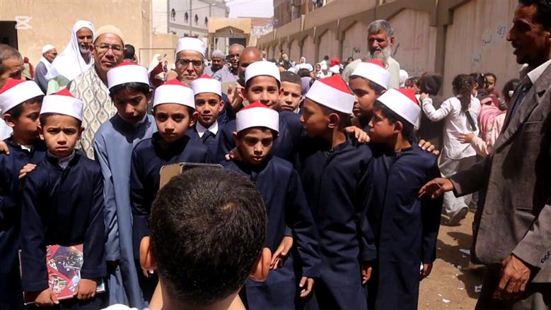 بالزي الأزهري طلاب معهد ديني ببني سويف ينظمون ممر شرفي لأمين التغذية لخروجه على المعاش