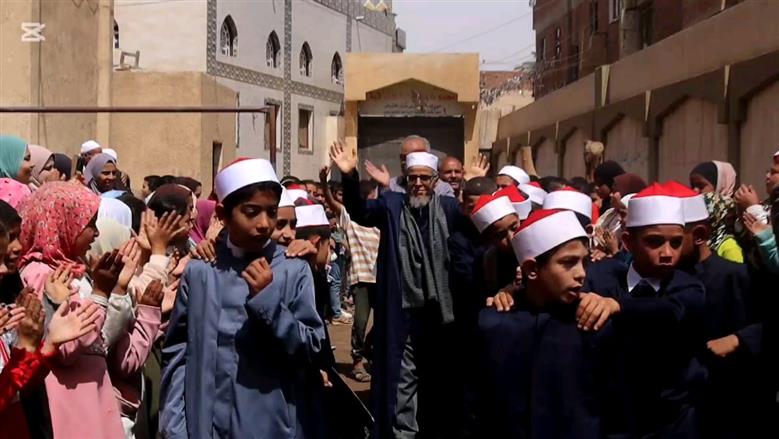 بالزي الأزهري طلاب معهد ديني ببني سويف ينظمون ممر شرفي لأمين التغذية لخروجه على المعاش