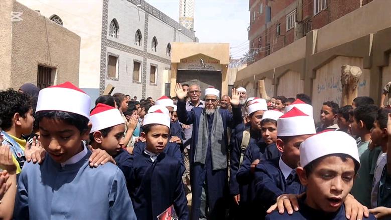 بالزي الأزهري طلاب معهد ديني ببني سويف ينظمون ممر شرفي لأمين التغذية لخروجه على المعاش