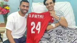 أحمد فتحي يزور المشجع الأهلاوي المصاب ويهديه قميصه