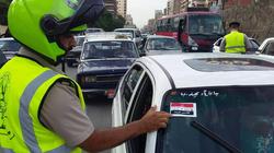 ملصقات بالتعريفة الجديدة على سيارات الميكروباص والتاكسي في الغربية