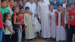 «ميلاد» يستقبل أطفال قريته بالحلوى على باب المسجد.. «عادة كل عيد»