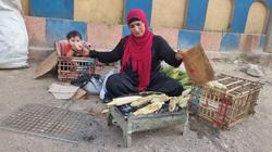 «صباح» بائعة الذرة على رصيف البدرشين بطفلين.. إيد بتشوي وإيد بترضع