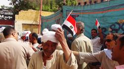رجال الشرطة توزع "علم مصر" على الناخبين في أسوان