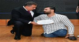 لحظة إنسانية.. محافظ الدقهلية ينحني ليساعد عاملًا من ذوي الهمم أثناء تكريمه